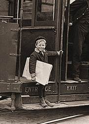 Photo Of Old-Fashioned Newsboy, Riding A Trolley