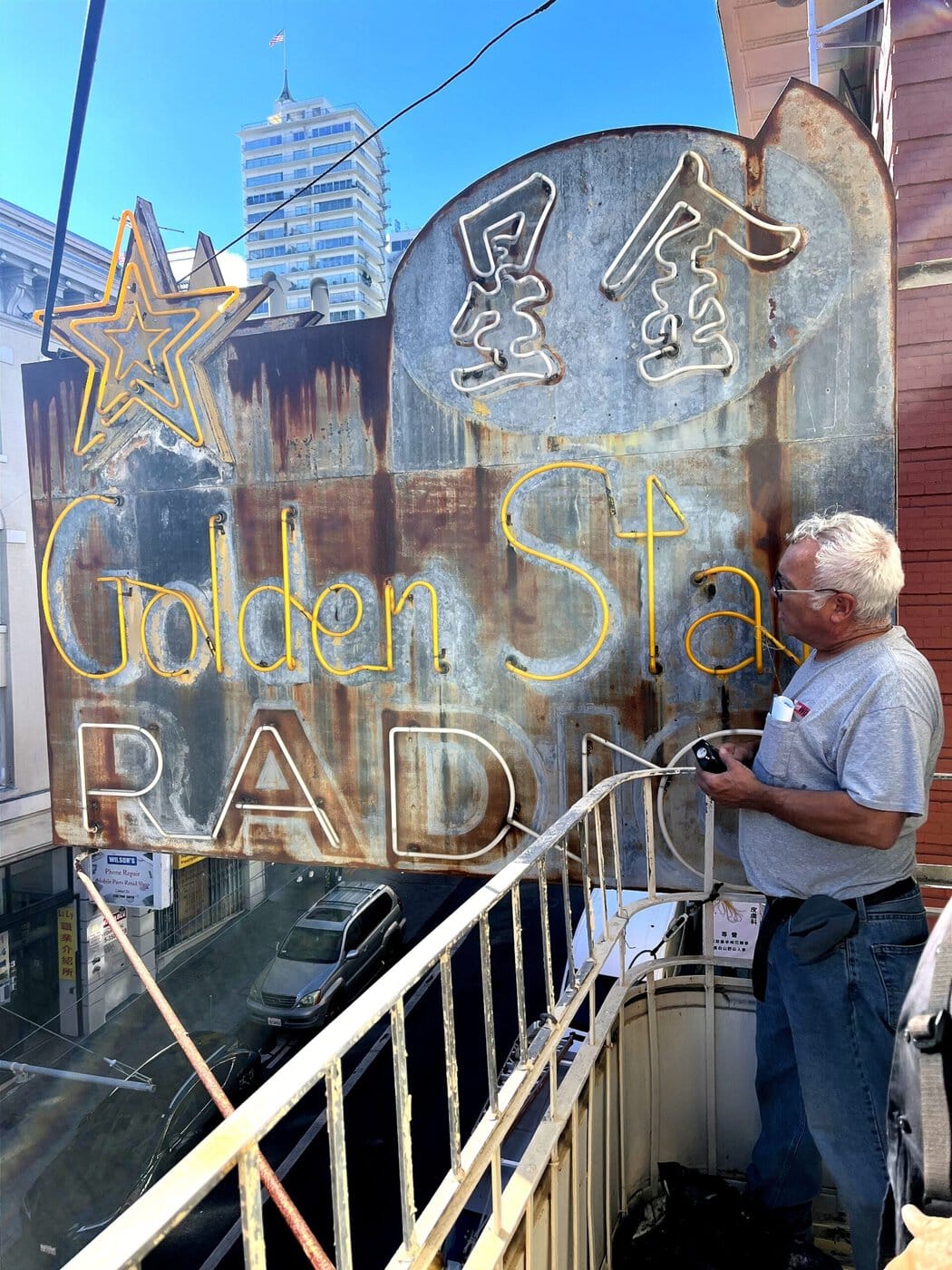 Jim Rizzo Examining The Rusted Golden Star Radio Neon Sign Before Restoration