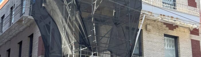 Three stories of scaffolding surrounding the Golden Star Radio sign during restoration in San Francisco's Chinatown